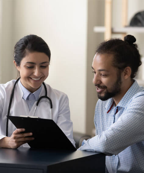 female doctor showing a male patient medical result in a clipboard