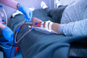 A nurse prepares a patient for hemodialysis