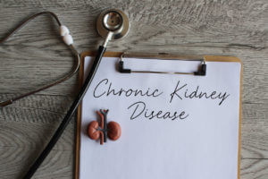 Stethoscope, kidney model and paper clipboard with text Chronic Kidney Disease.