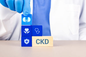 Nephrologist's hand arranges wooden cubes with kidney icons.